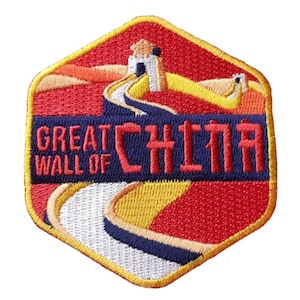 Può includere: Toppa ricamata raffigurante la Grande Muraglia Cinese. La toppa è a forma esagonale con sfondo rosso e bordo giallo. Le parole "GREAT WALL OF CHINA" sono ricamate in rosso e blu.