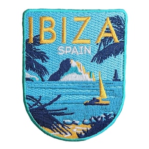 Puede incluir: Parche bordado con la palabra "IBIZA" en amarillo y "SPAIN" debajo. El diseño incluye una escena costera con un velero, palmeras y una montaña. El parche tiene una combinación de colores azul y turquesa.