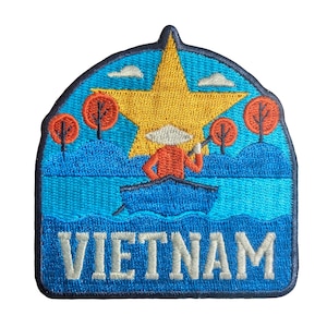 May include: Embroidered patch depicting a Vietnamese scene. A person in a boat rows on blue water, with a large yellow star and orange trees. The word "VIETNAM" is embroidered in white.