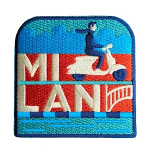May include: Embroidered patch with a scooter rider in blue, and the cream text "MI LAN". The design includes a blue cityscape, a bridge, and a red and blue background. The patch is bordered in blue.