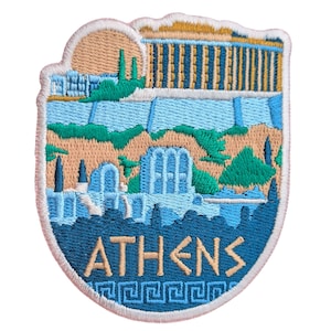 May include: Embroidered patch featuring a stylized depiction of Athens, Greece. The design includes the Parthenon, other architectural elements, and the city name "ATHENS" in a decorative font. The patch has a blue, beige, and green color scheme.
