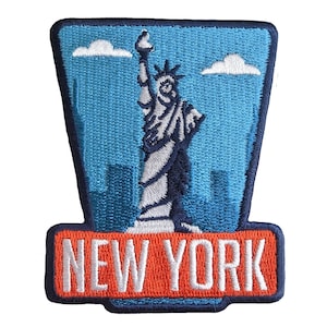 Può includere: Toppa ricamata raffigurante la Statua della Libertà su uno sfondo di cielo blu con nuvole bianche e uno skyline. La toppa ha un bordo arancione con la scritta "NEW YORK" in bianco.