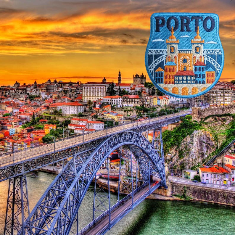 Op de afbeelding: Een schilderachtig uitzicht op Porto, Portugal, met een blauwe metalen brug over een rivier en een stadsgezicht op de achtergrond. Een blauwe patch met het woord "PORTO" en een gedetailleerde illustratie van gebouwen en torens bevindt zich in de rechterbovenhoek.