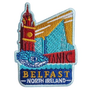 Puede incluir: Un parche bordado que muestra una torre de reloj roja, un barco azul y un pez estilizado. El texto dice TITANIC, BELFAST y NORTH IRELAND. El diseño utiliza colores vibrantes que incluyen amarillo, azul claro y azul oscuro.