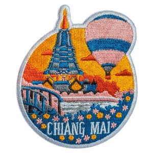 Puede incluir: Parche bordado con una escena colorida con una pagoda, un globo aerostático y el texto "CHIANG MAI". El parche tiene un borde blanco y está en tonos de azul, naranja, rosa y amarillo.