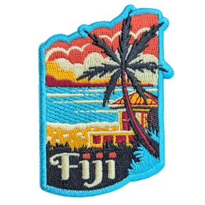 Puede incluir: Parche bordado con una escena de playa tropical con una palmera, el océano y una puesta de sol. La palabra "Fiji" está bordada en blanco. El parche tiene un borde azul y tiene la forma de un contorno de isla.