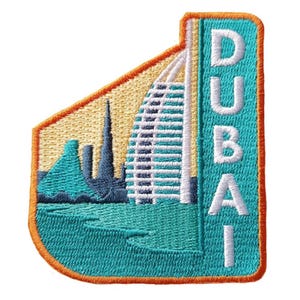 Può includere: Toppa ricamata raffigurante lo skyline di Dubai, compreso l'hotel Burj Al Arab, con la scritta "DUBAI". La toppa è turchese, beige e arancione, con dettagli di cucitura intricati.