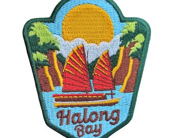 Könnte beinhalten: Gestickter Aufnäher mit einer Szene der Halong-Bucht. Das Design zeigt eine gelbe Sonne, rot besegelte Boote und den Text "Halong Bay" in einer dekorativen Schriftart, alles vor einem blauen und grünen Hintergrund.