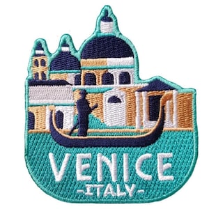Puede incluir: Parche bordado con un diseño de Venecia, Italia. El parche muestra una góndola, edificios y cúpulas en tonos turquesa, azul marino, dorado y blanco. Las palabras "VENICE" e "ITALY" están bordadas en blanco.