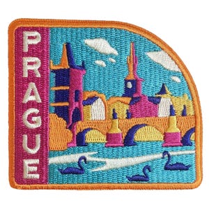 Puede incluir: Parche bordado con una colorida representación de Praga. El diseño incluye el nombre de la ciudad en rosa, un puente, edificios y cisnes sobre un fondo turquesa. El parche tiene un borde naranja.
