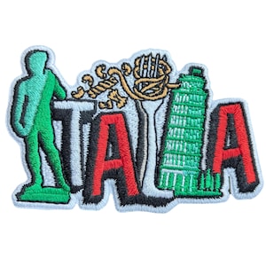 Puede incluir: Parche bordado con la palabra "ITALIA" en letras rojas con contornos negros. El parche incluye una figura verde, un diseño dorado y una ilustración verde de la Torre de Pisa, todo sobre un fondo blanco.