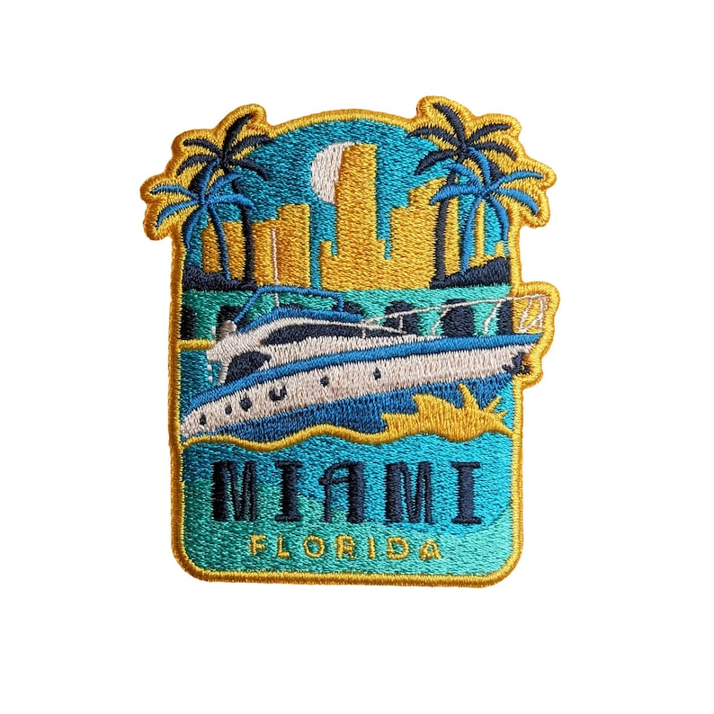Op de afbeelding: Een blauwe en gouden geborduurde patch met een jacht op het water, palmbomen en de tekst "MIAMI FLORIDA".