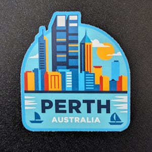 May include: A sticker depicting Perth, Australia, with a cityscape in blue, orange, and yellow. The word "PERTH" is in white, with "AUSTRALIA" beneath. Includes a sun and sailboats.