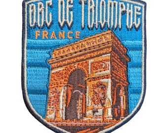 Puede incluir: Parche bordado en forma de escudo con el Arco del Triunfo de París, Francia. El parche tiene un fondo azul con el texto "ARC DE TRIOMPHE FRANCE". El monumento está representado en tonos naranja y marrón.