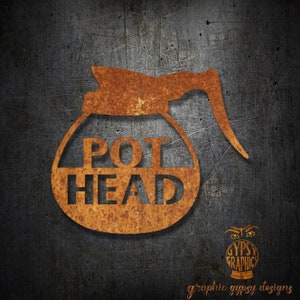 May include: Rusty metal cutout of a coffee pot with the words "POT HEAD" inside. The cutout is on a dark gray background.