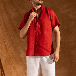 a man in a red shirt and white shorts