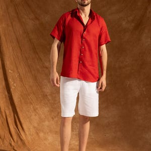 a man in a red shirt and white shorts