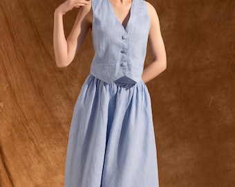 May include: A light blue linen vest and skirt set. The sleeveless vest has a V-neck and button closure. The skirt is a flowing, midi-length design. The outfit is made of a soft, textured fabric, perfect for a summer look.