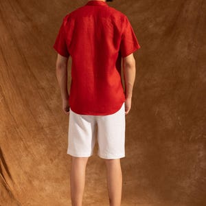 a man in a red shirt and white shorts