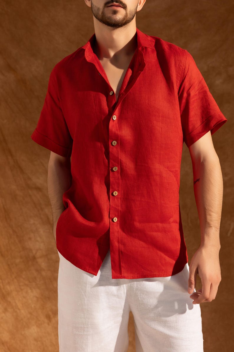 a man wearing a red shirt and white pants