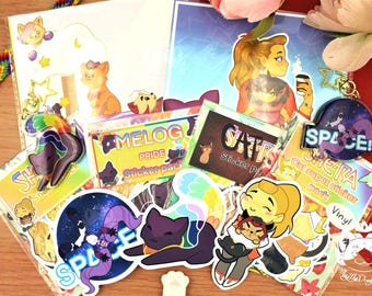 Puede incluir: Una colección de pegatinas coloridas y un llavero con gatos y personajes de dibujos animados. Las pegatinas tienen varios diseños, incluyendo gatos en el espacio, arcoíris y texto que dice "SPACE!", "MELOG PRIDE" y "SHE-RA Cat super sticker pack".