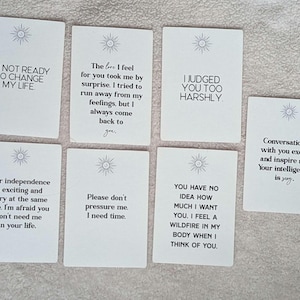 Puede incluir: Siete tarjetas rectangulares blancas dispuestas en una cuadrícula, cada una con un pequeño icono de sol en la parte superior y texto impreso en negro. Las tarjetas contienen varios mensajes emocionales, incluyendo frases como I'M NOT READY TO CHANGE MY LIFE.