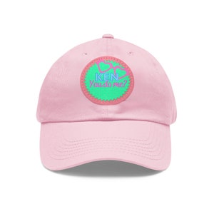 May include: Pink baseball cap with a green and pink patch that says "KEN You do me?"