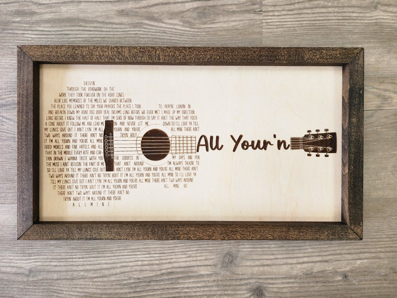 May include: A wooden sign with a brown frame featuring the lyrics to the song "All Your'n" by the band "The Band Perry". The lyrics are printed in a brown font and the sign includes a silhouette of a guitar.
