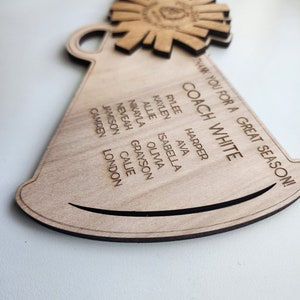 May include: A wooden megaphone with the text "THANK YOU FOR A GREAT SEASON! COACH WHITE" and a list of names: Rylee, Harper, Kaylen, Ava, Allie, Isabella, Nikayla, Olivia, Neveah, Grayson, Jamison, Calie, Camren, London.