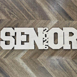 May include: Wooden sign with the word "SENIOR" and the year "2022" in white letters.