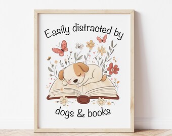 Puede incluir: Una impresión enmarcada en blanco con el texto "Fácilmente distraído por perros y libros" y una ilustración de dibujos animados de un perro durmiendo sobre un libro abierto con flores alrededor.