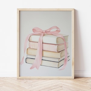 Pode incluir: Uma pilha de livros amarrados com uma fita rosa. A fita está amarrada em um laço no topo dos livros.