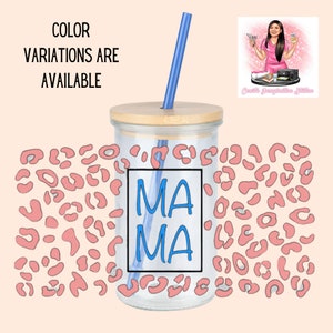 May include: A clear glass tumbler with a wooden lid and a blue straw. The tumbler has a pink leopard print design and the words "MA MA" written in blue on the front.