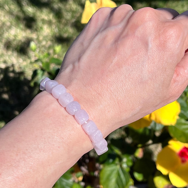 Pu&ograve; includere: Un braccialetto elastico composto da perline lisce, rosa pallido, a forma di cubo. Le perline sono uniformi per dimensioni e forma, infilate in un'unica fila per formare un anello continuo che si adatta al polso con una tonalit&agrave; pastello.