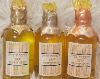 May include: Three decorative glass bottles filled with a yellow liquid. Each bottle has a unique, crystal-like topper and a label that reads "POTION OF SPEED". The bottles have gold and bronze accents.