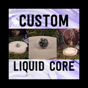 May include: Custom liquid core dice with black and white numbers on a black background. The dice is sitting on a wooden display stand. The image also shows a green gemstone and a metal stand with a red gemstone.
