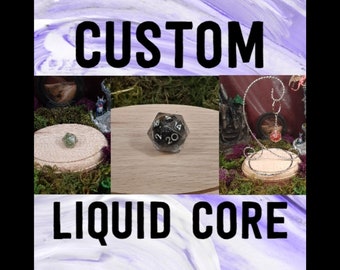 May include: Custom liquid core dice with black and white numbers on a black background. The dice is sitting on a wooden display stand. The image also shows a green gemstone and a metal stand with a red gemstone.