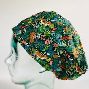 May include: Green scrub hat with a jungle print featuring tigers, birds, and flowers.