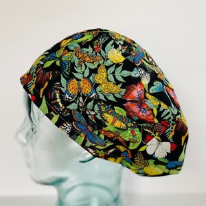 May include: A black scrub hat with a colorful butterfly print. The hat is made of a soft, comfortable fabric and is perfect for nurses, doctors, and other healthcare professionals.