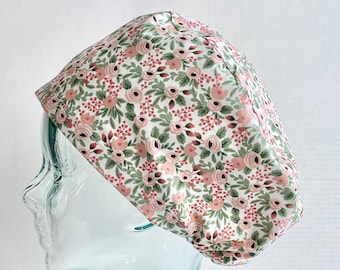 Puede incluir: Una cofia blanca con estampado floral rosa y verde. La cofia está hecha de una tela suave y cómoda y está diseñada para ser usada por profesionales médicos.
