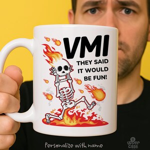Può includere: Tazza in ceramica bianca con la scritta "VMI THEY SAID IT WOULD BE FUN!" e uno scheletro dei cartoni animati in fiamme. La tazza ha anche la scritta "Personalize with name".