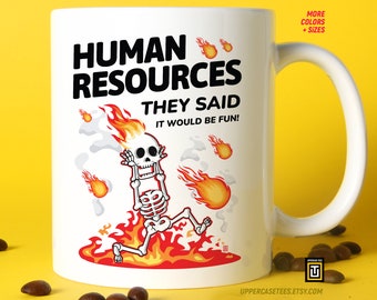 May include: White ceramic mug with a black and red illustration of a skeleton on fire. The text "HUMAN RESOURCES THEY SAID IT WOULD BE FUN!" is printed on the mug.