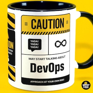 Może przedstawiać: Biały kubek ceramiczny z czarnym uchwytem i obręczą. Kubek ma żółto-czarne ostrzegawcze znaki z tekstem "CAUTION" i "MAY START TALKING ABOUT DevOps" w kolorze czarnym. Tekst "YADA! YADA! YADA!" znajduje się w dymku. Kubek ma czarny symbol nieskończoności i tekst "APPROACH AT YOUR OWN RISK!" w kolorze czarnym.