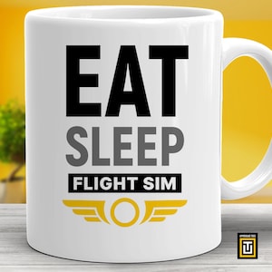May include: White ceramic coffee mug with black text that reads "Eat Sleep Flight Sim" and a yellow and gray airplane wing logo.