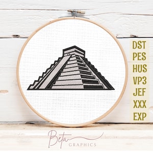 May include: Embroidered design of a stepped pyramid in black thread on white fabric, set within a wooden embroidery hoop. The design is detailed and geometric. The text "Beta Graphics" is at the bottom. The image also includes the text "DST PES HUS VP3 JEF XXX EXP".