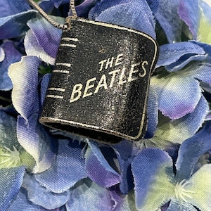 Beatles collectible miniature photo album necklace.