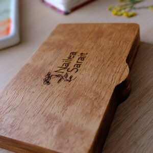 Puede incluir: Una caja de madera con un dise&ntilde;o floral y el nombre "Nailea Sarai" grabado en la parte superior.