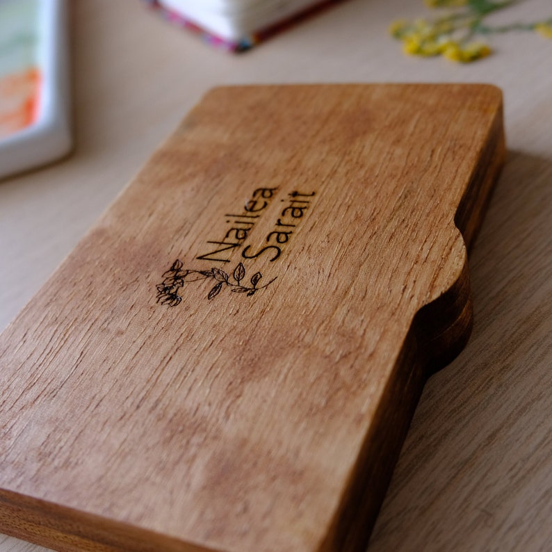 Puede incluir: Una caja de madera con un dise&ntilde;o floral y el nombre "Nailea Sarai" grabado en la parte superior.