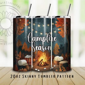 May include: A set of three 20oz skinny tumblers with a fall-themed design. The tumblers feature a campfire scene with the words "Campfire Season" and illustrations of trees, a fire, marshmallows, and blankets. Each tumbler has a black straw.