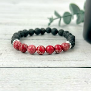 May include: A red and black beaded bracelet with lava rock and red jasper beads.